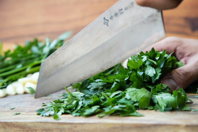 Hand chopping herbs on a cutting board