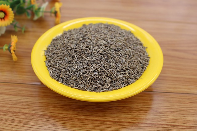 Dried cumin seeds on a yellow plate