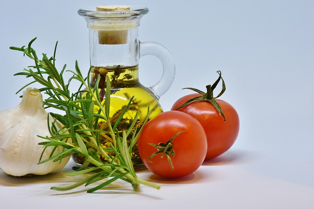 Garlic, oil, tomato and rosemary on a white surface