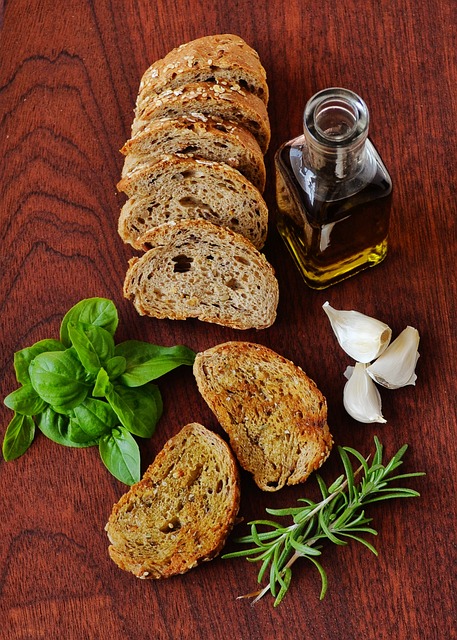 Sliced brown bread with olive oil and staple Mediterranean herbs on the side