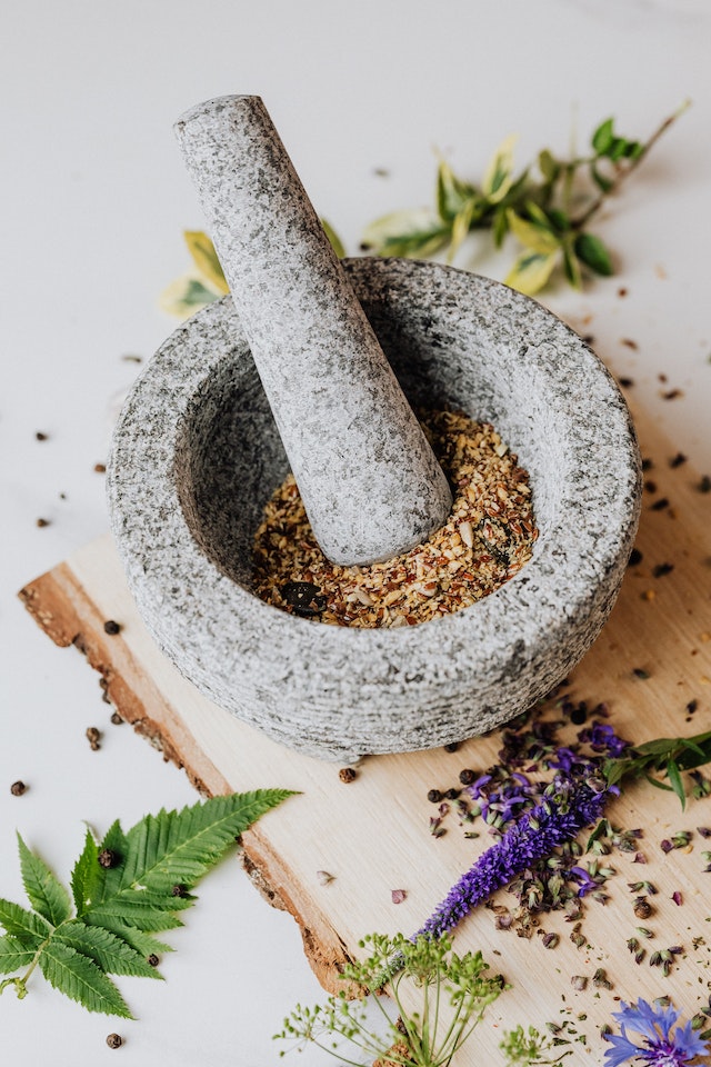 A mortar and pestle containing ground herbs and spices