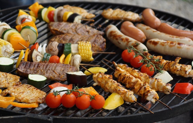 Assorted vegetables, meats and sausages on a grill