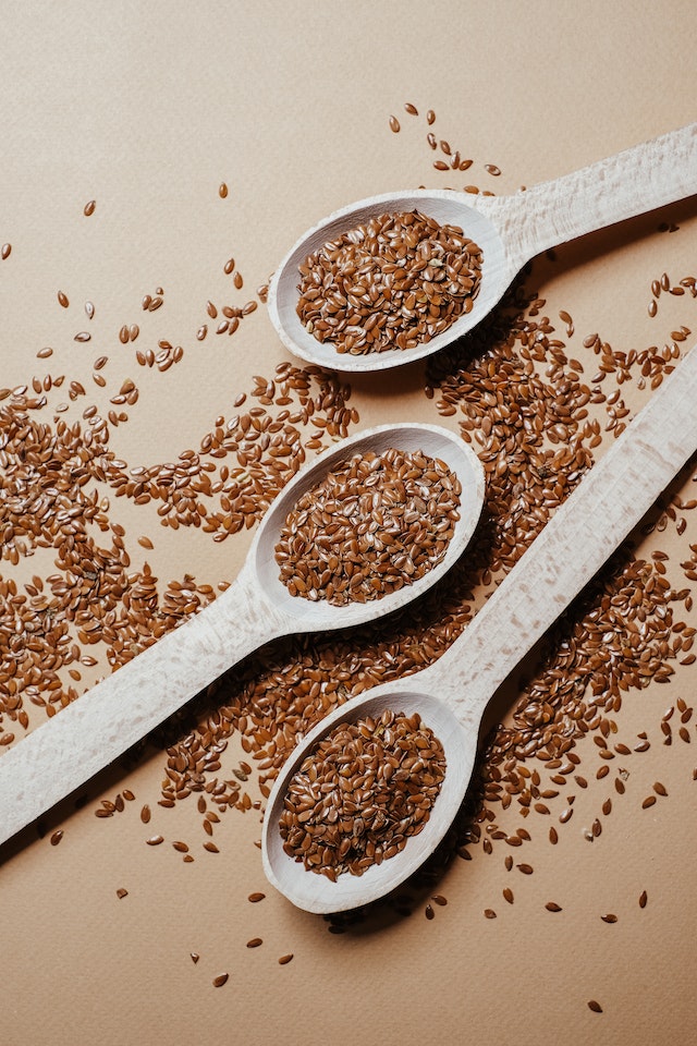 Wooden spoons filled with flax seeds