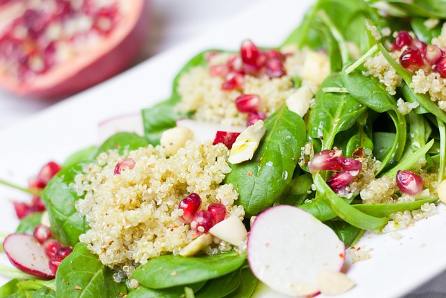 Pomegranate, spinach and slices of radish on a white plate