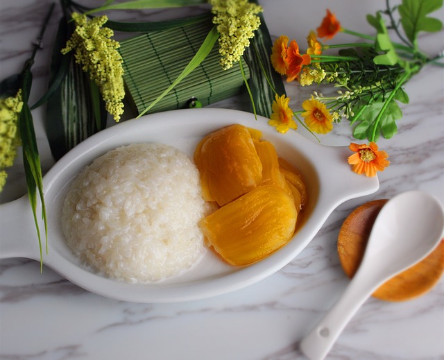 Sticky rice and slices of mango on a white ceramic dish