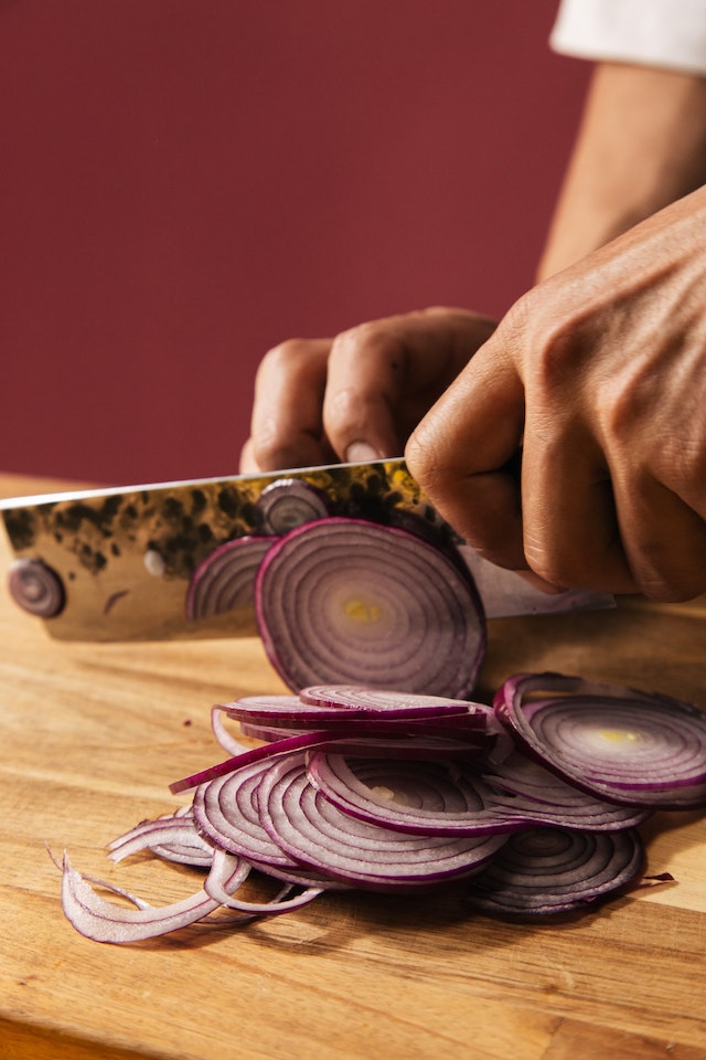 Hand slicing red onions
