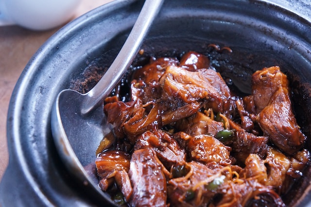 Braised meat in black ceramic pot