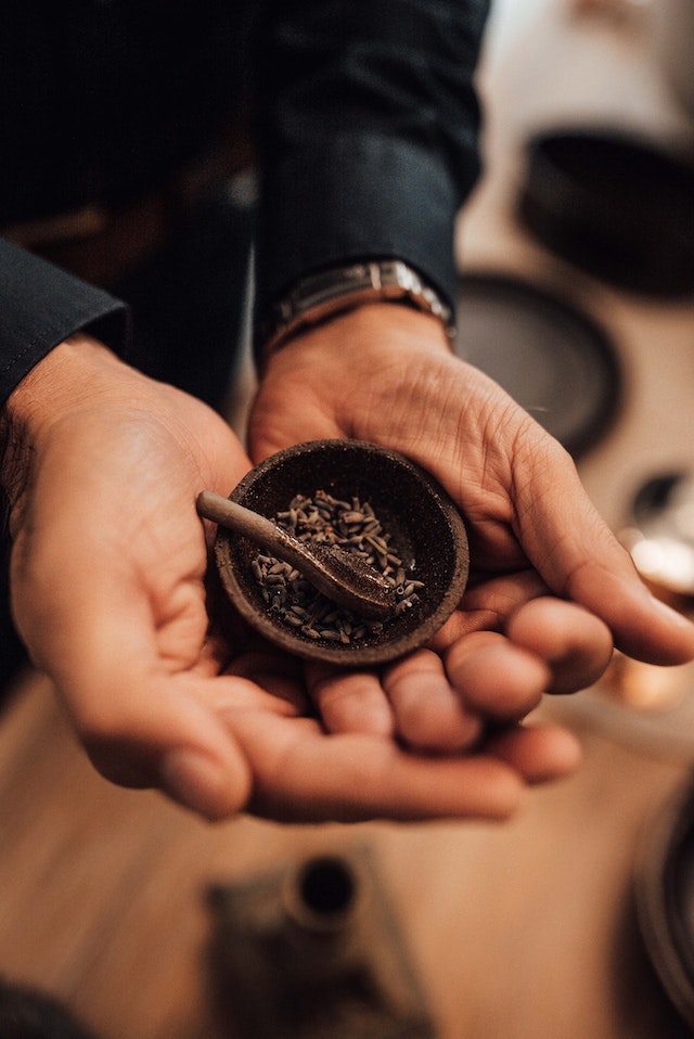 Person holding a tiny bowl of cumin seeds