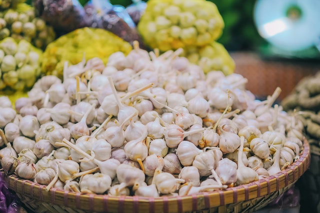 A pile of garlic bulbs on a basket