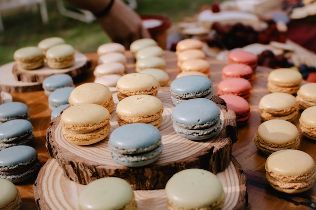 Different colored macarons on wooden boards