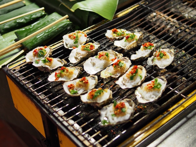 Fresh oysters cooking on a grill