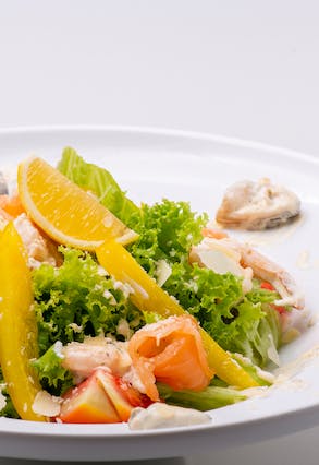 A plate of salad with slices of fresh oranges