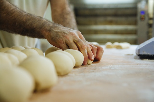 A person shaping balls of dough